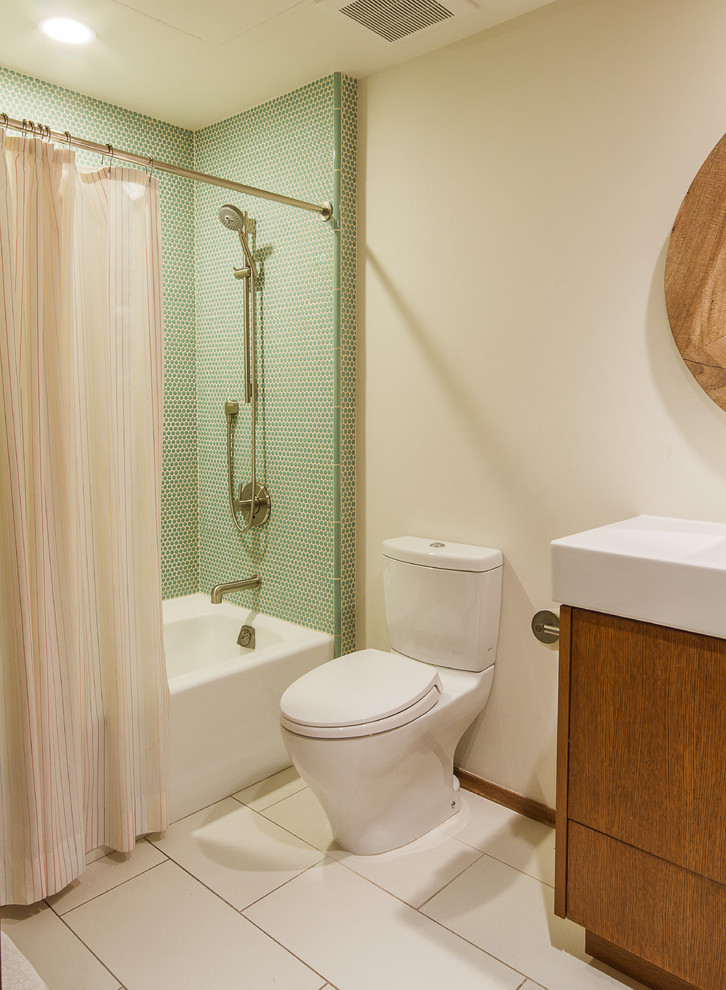 Mid-sized minimalist kids' ceramic tile and green tile ceramic tile and white floor bathroom photo in Salt Lake City with an integrated sink, flat-panel cabinets, medium tone wood cabinets, quartz countertops, a two-piece toilet and white walls