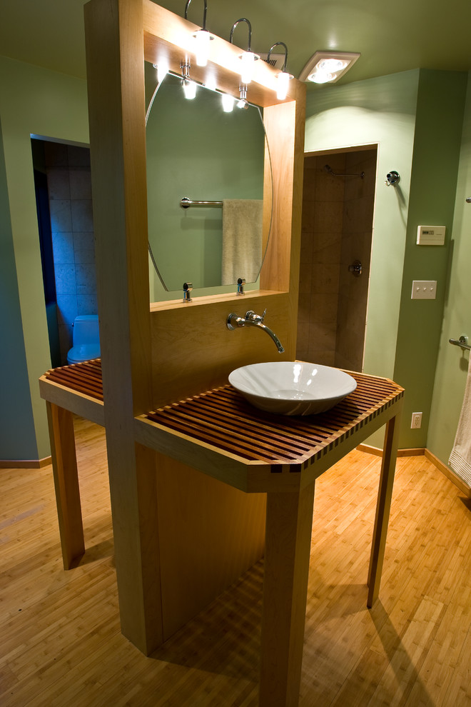 Inspiration för ett litet rustikt brun brunt badrum med dusch, med öppna hyllor, skåp i ljust trä, en toalettstol med hel cisternkåpa, gröna väggar, bambugolv, ett fristående handfat, träbänkskiva och brunt golv