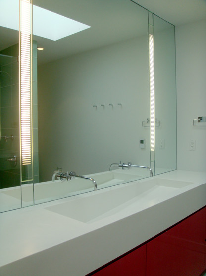 Foto de cuarto de baño minimalista de tamaño medio con armarios con paneles lisos, puertas de armario rojas, aseo y ducha y encimera de acrílico