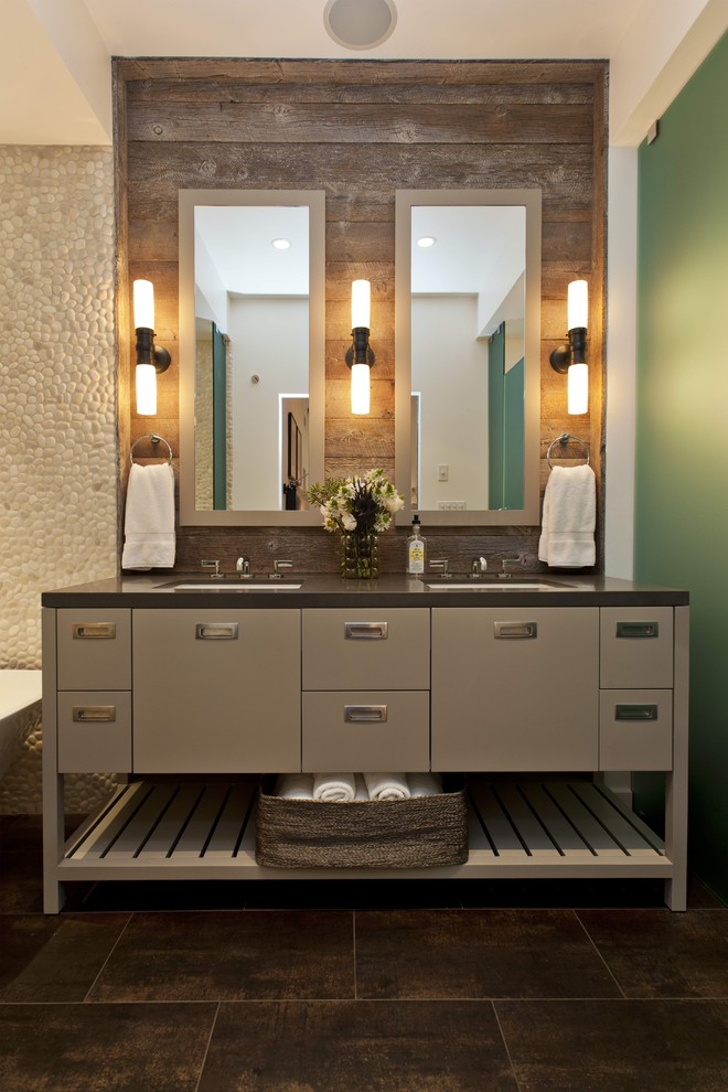 サンフランシスコにあるラスティックスタイルのおしゃれな浴室 (アンダーカウンター洗面器、フラットパネル扉のキャビネット、グレーのキャビネット、茶色いタイル、石タイル、照明) の写真