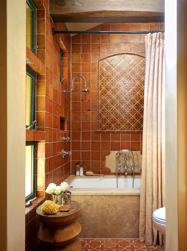 Esempio di una stanza da bagno padronale mediterranea di medie dimensioni con vasca sottopiano, piastrelle multicolore, pareti beige, pavimento in terracotta, piastrelle in terracotta, vasca/doccia, WC monopezzo e doccia con tenda