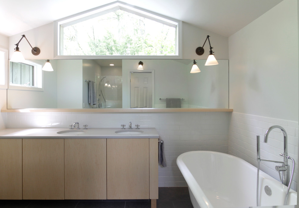 Exempel på ett modernt badrum, med släta luckor, skåp i ljust trä, ett fristående badkar, en dusch i en alkov och ett undermonterad handfat
