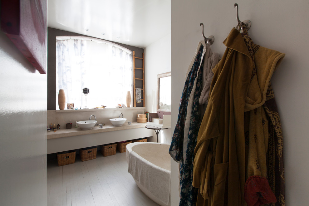 Ispirazione per una stanza da bagno padronale eclettica di medie dimensioni con top in marmo, vasca freestanding, pareti bianche e pavimento in legno verniciato