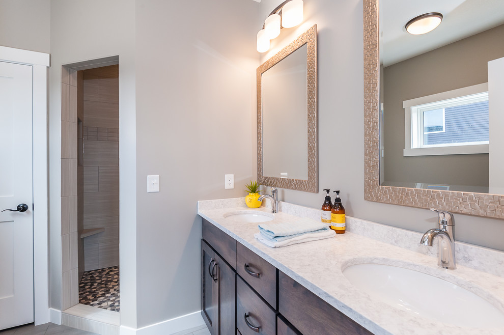 Mid-sized farmhouse master brown tile and porcelain tile alcove shower photo in Other with shaker cabinets, dark wood cabinets, gray walls, an undermount sink, granite countertops and a hinged shower door