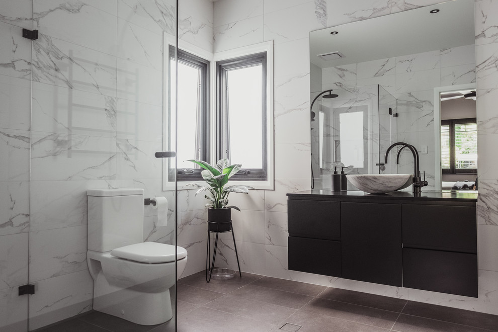 セントラルコーストにあるコンテンポラリースタイルのおしゃれな浴室 (フラットパネル扉のキャビネット、黒いキャビネット、バリアフリー、白いタイル、白い壁、ベッセル式洗面器、茶色い床、オープンシャワー、黒い洗面カウンター) の写真