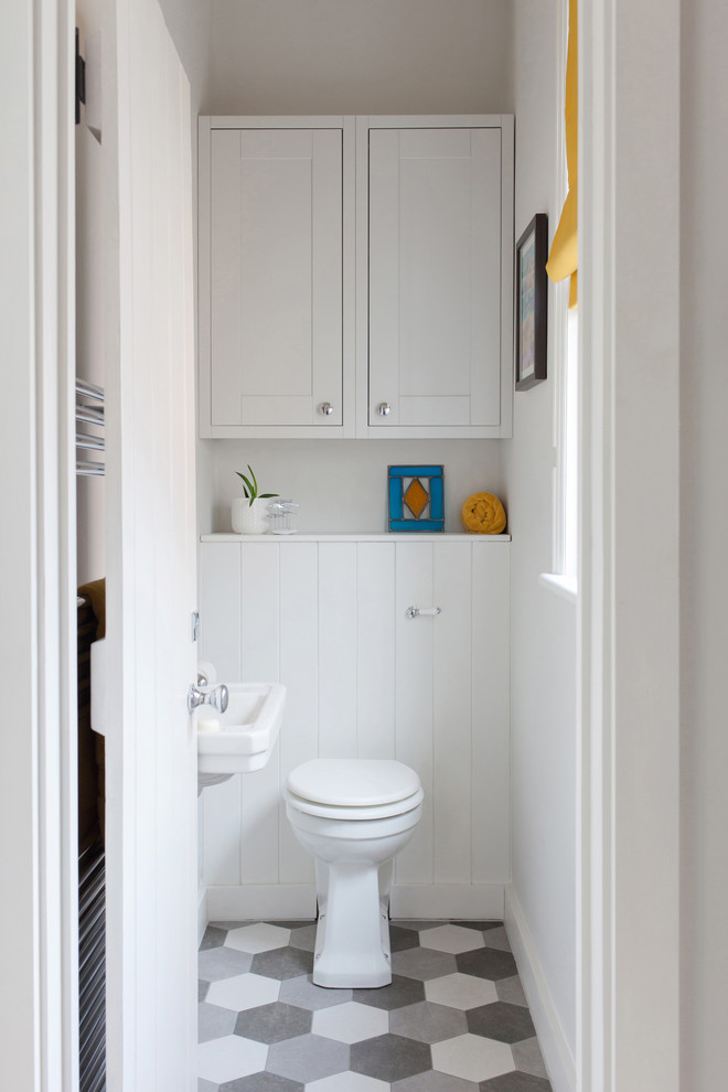 Immagine di una piccola stanza da bagno minimal con WC a due pezzi, pareti grigie, pavimento in gres porcellanato, lavabo sospeso e pavimento multicolore