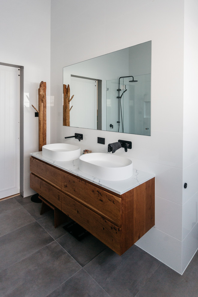 Photo of a small coastal ensuite bathroom in Central Coast with freestanding cabinets, light wood cabinets, a walk-in shower, white tiles, ceramic tiles, ceramic flooring, engineered stone worktops, grey floors and white worktops.