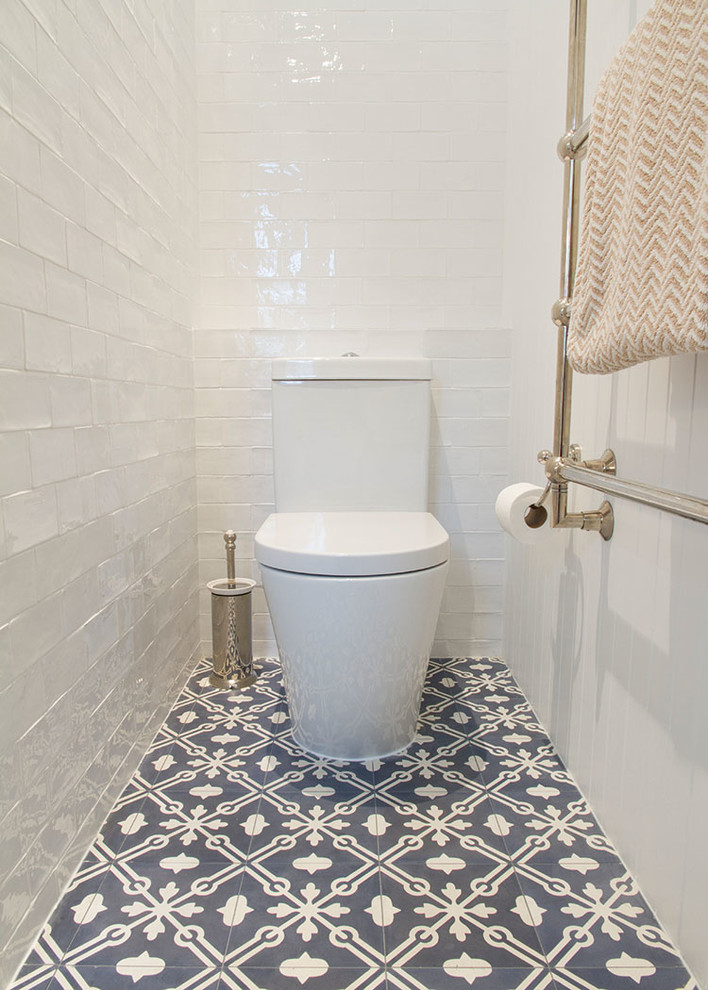 Photo of a large country ensuite bathroom in Sydney with recessed-panel cabinets, white cabinets, a walk-in shower, white tiles, ceramic tiles, white walls, cement flooring, a built-in sink and marble worktops.