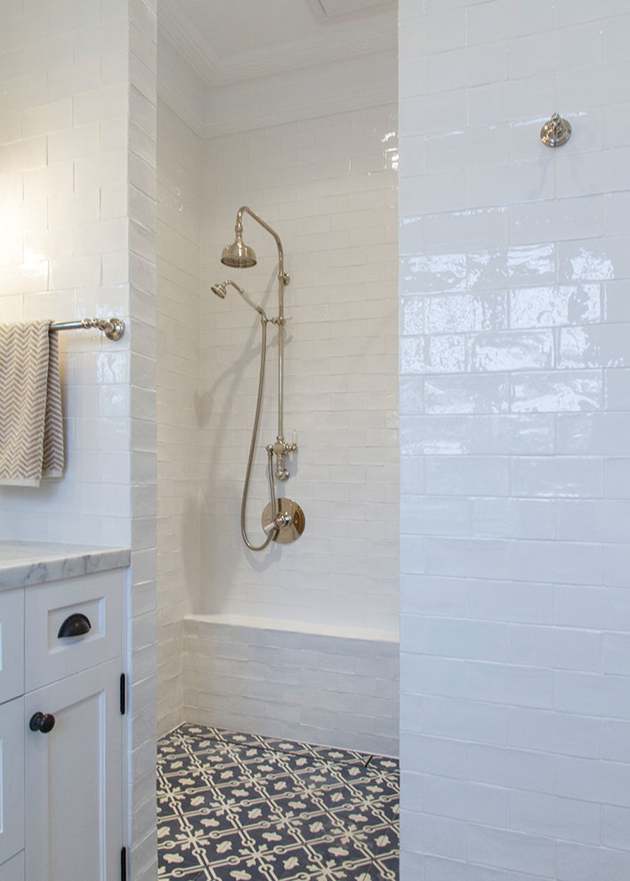 Large country ensuite bathroom in Sydney with recessed-panel cabinets, white cabinets, a walk-in shower, white tiles, ceramic tiles, white walls, cement flooring, a built-in sink and marble worktops.