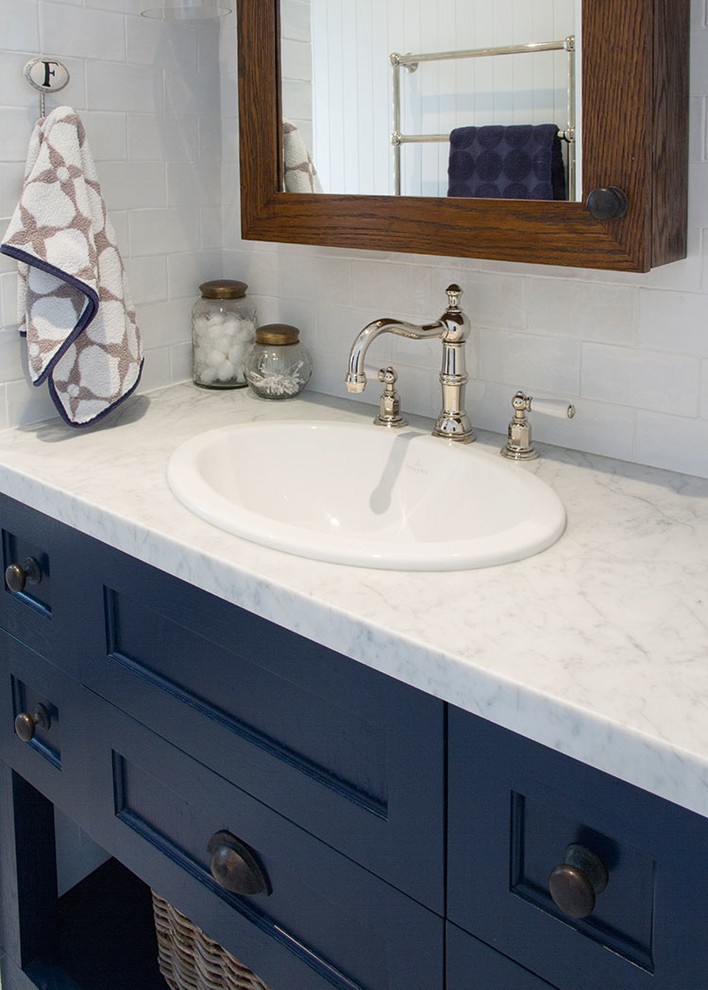 Inredning av ett lantligt stort badrum med dusch, med luckor med infälld panel, en öppen dusch, vit kakel, keramikplattor, vita väggar, ett nedsänkt handfat, marmorbänkskiva, en toalettstol med separat cisternkåpa, marmorgolv och blå skåp