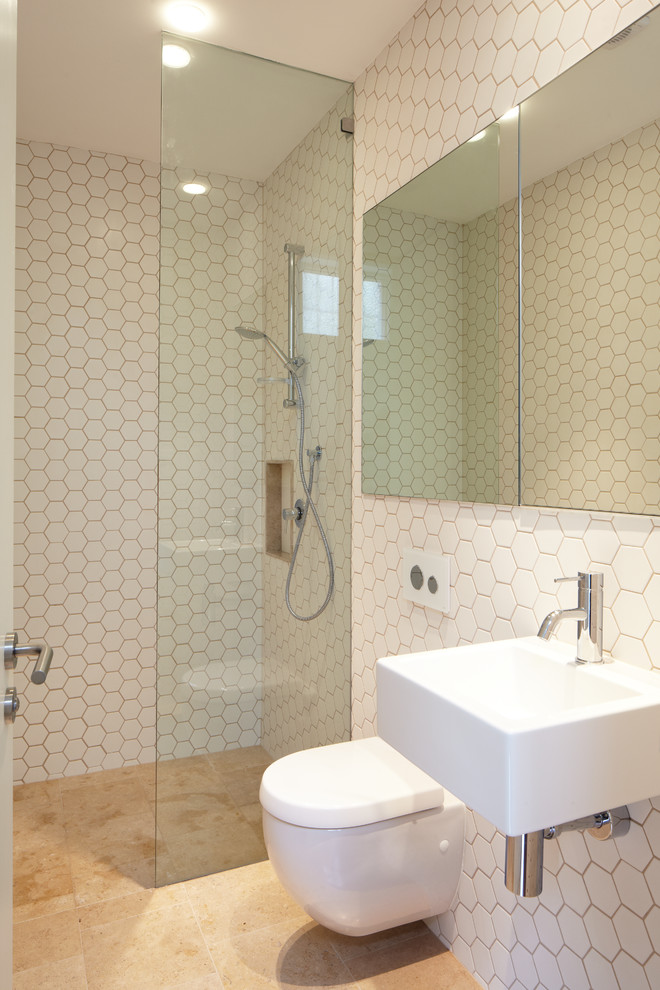 На фото: главная ванная комната среднего размера в современном стиле с подвесной раковиной, плоскими фасадами, душем без бортиков, инсталляцией, белой плиткой, керамической плиткой, полом из керамической плитки и белыми стенами с