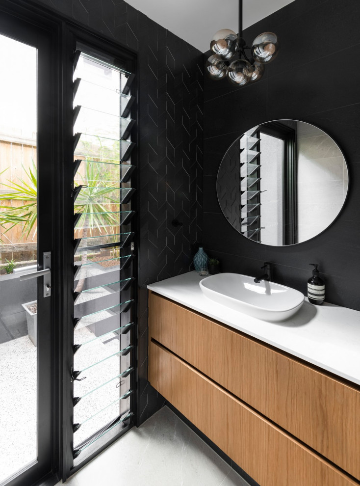 Идея дизайна: большая ванная комната в современном стиле с фасадами цвета дерева среднего тона, черной плиткой, душевой кабиной и белой столешницей