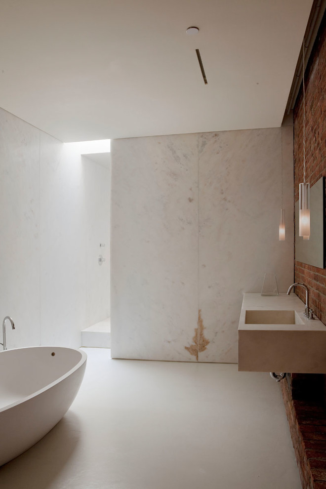 Großes Industrial Badezimmer En Suite mit freistehender Badewanne, Duschnische, bunten Wänden, Betonboden, integriertem Waschbecken und Kalkstein-Waschbecken/Waschtisch in New York