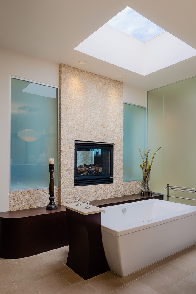 Modelo de cuarto de baño contemporáneo con bañera exenta y baldosas y/o azulejos beige