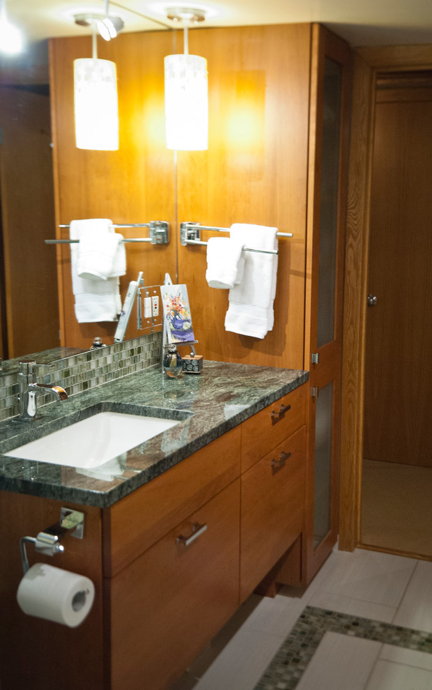 Idéer för ett modernt badrum, med ett undermonterad handfat, skåp i mellenmörkt trä, granitbänkskiva, beige kakel och glaskakel