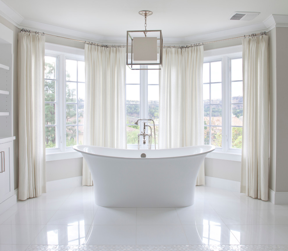Ejemplo de cuarto de baño clásico renovado grande con bañera exenta, baldosas y/o azulejos blancos, paredes grises y suelo de mármol