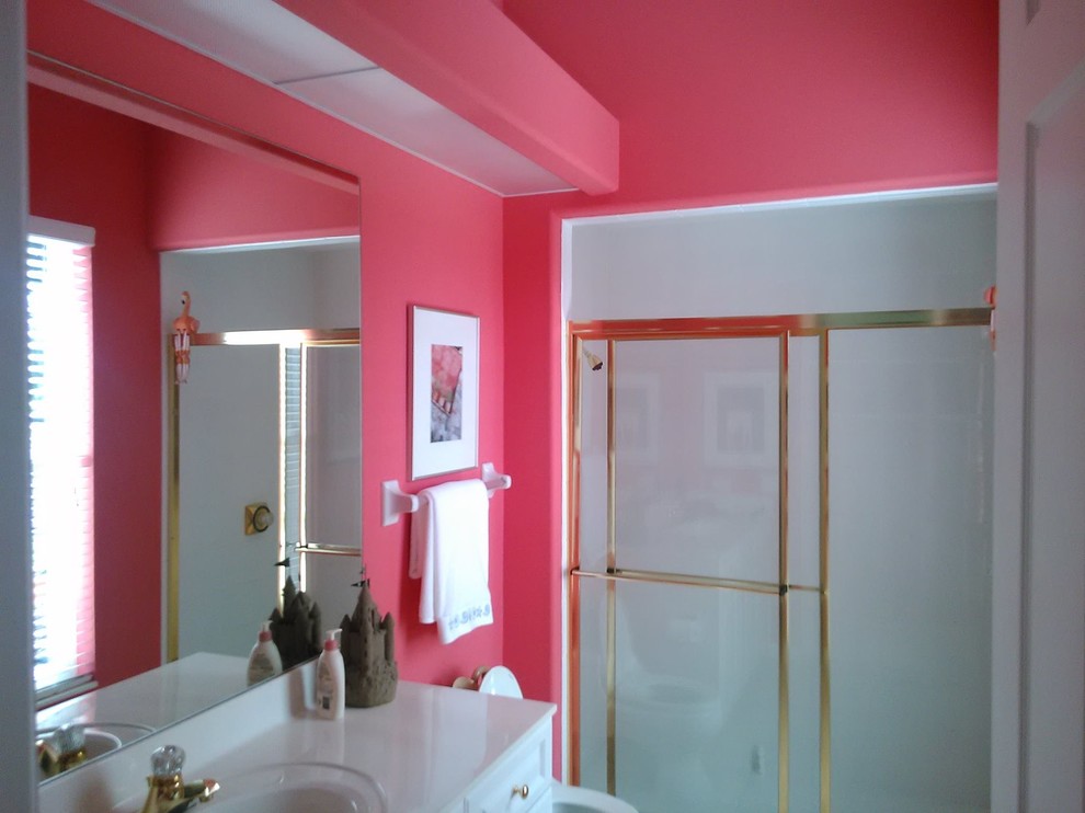 Cette photo montre une douche en alcôve de taille moyenne avec un placard avec porte à panneau encastré, des portes de placard blanches, un mur rose, un lavabo encastré et un plan de toilette en surface solide.