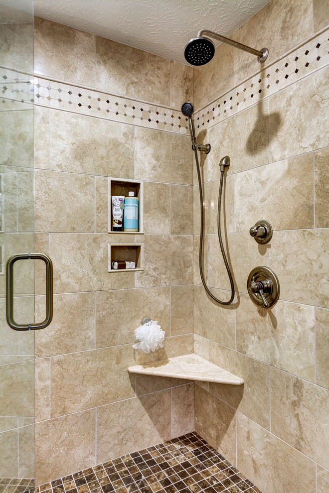 Cette image montre une douche en alcôve traditionnelle en bois foncé avec un lavabo encastré, un placard avec porte à panneau encastré, un plan de toilette en granite, un carrelage beige et un carrelage de pierre.