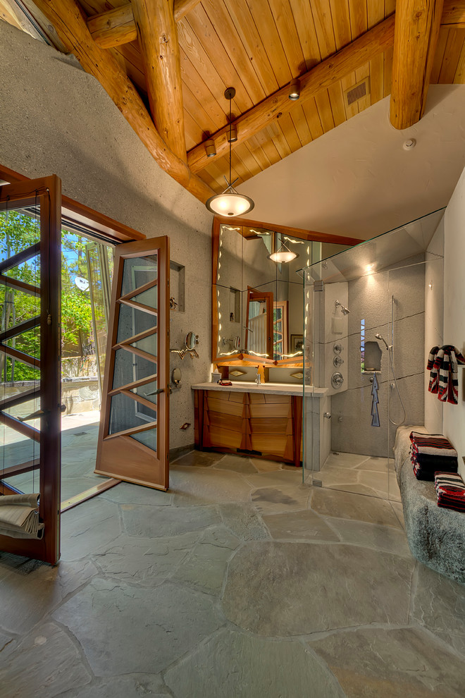 Cette image montre une très grande salle de bain principale bohème en bois clair avec un placard en trompe-l'oeil, une baignoire posée, un carrelage gris, un mur vert, un sol en calcaire, un lavabo encastré, un plan de toilette en granite et un sol gris.