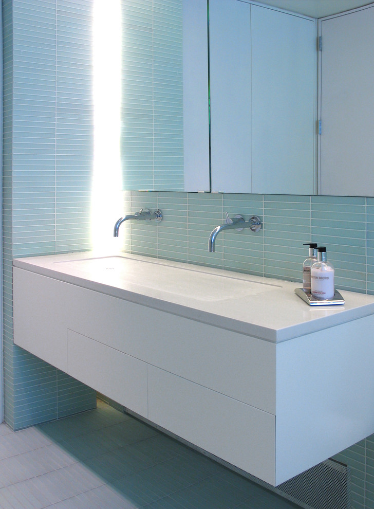 Inspiration pour une salle de bain design avec une grande vasque, un placard à porte plane, des portes de placard blanches et un carrelage bleu.