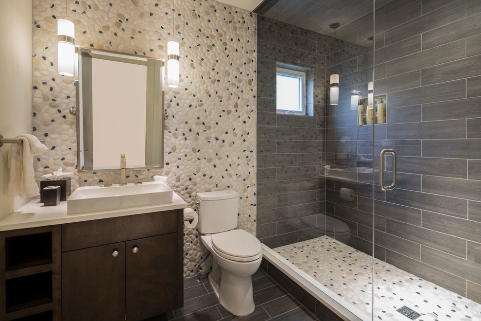 Inspiration for a small transitional 3/4 pebble tile ceramic tile and black floor alcove shower remodel in Santa Barbara with flat-panel cabinets, dark wood cabinets, a one-piece toilet, a vessel sink, quartz countertops and a hinged shower door