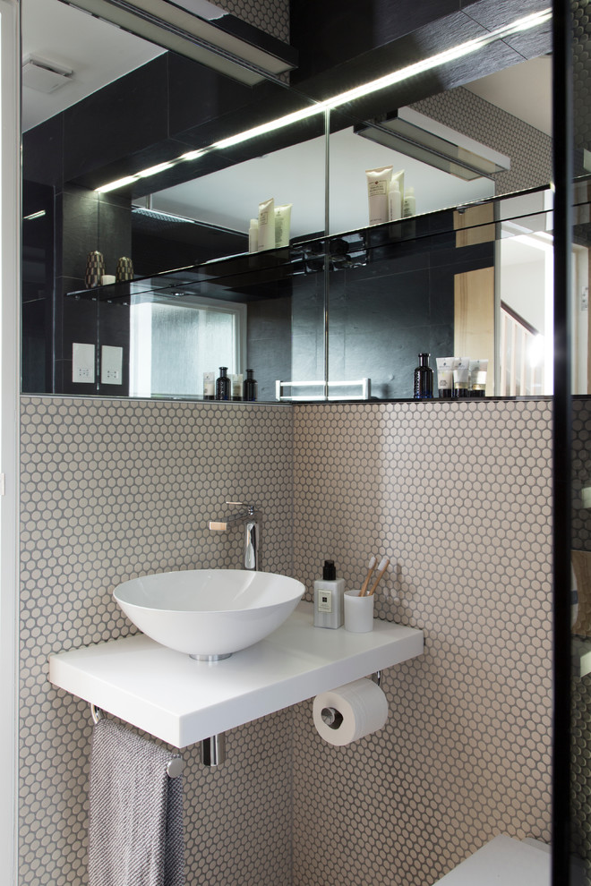 Bild på ett litet eklektiskt vit vitt badrum med dusch, med en öppen dusch, en vägghängd toalettstol, grå kakel, porslinskakel, grå väggar, klinkergolv i porslin, bänkskiva i kvarts och med dusch som är öppen