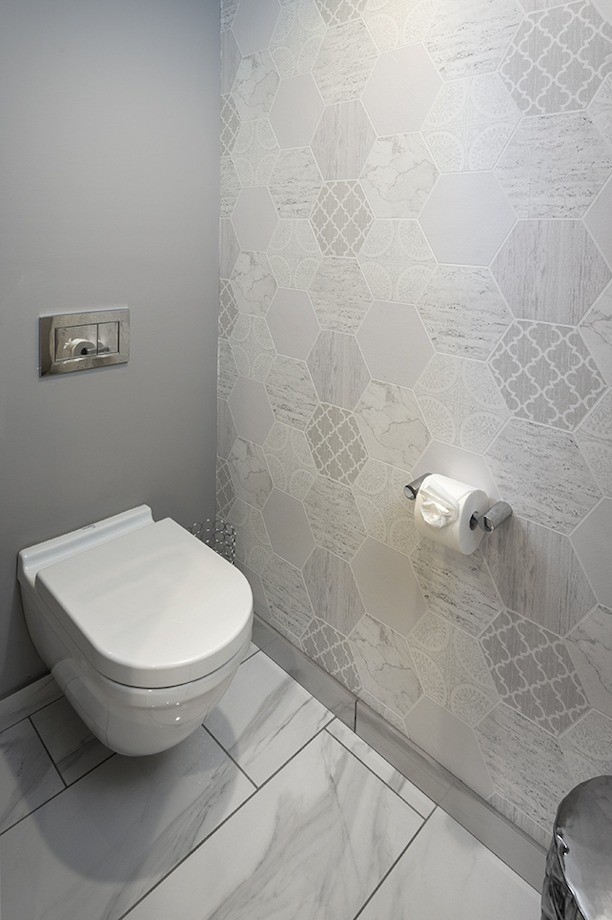 Идея дизайна: туалет среднего размера в стиле неоклассика (современная классика) с фасадами в стиле шейкер, серыми фасадами, инсталляцией, белой плиткой, керамогранитной плиткой, серыми стенами, полом из керамогранита, накладной раковиной, столешницей из кварцита, белым полом, белой столешницей, встроенной тумбой и обоями на стенах