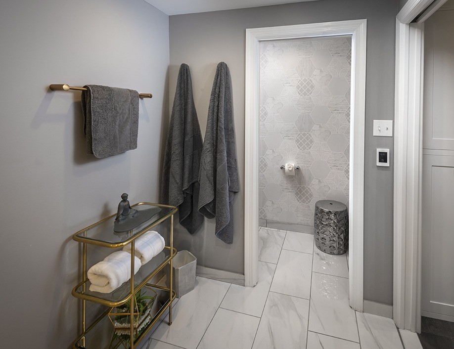 Пример оригинального дизайна: главная ванная комната среднего размера в стиле неоклассика (современная классика) с фасадами в стиле шейкер, серыми фасадами, инсталляцией, белой плиткой, керамогранитной плиткой, серыми стенами, полом из керамогранита, накладной раковиной, столешницей из кварцита, белым полом, белой столешницей, двойным душем, душем с распашными дверями, сиденьем для душа, тумбой под две раковины, встроенной тумбой и обоями на стенах
