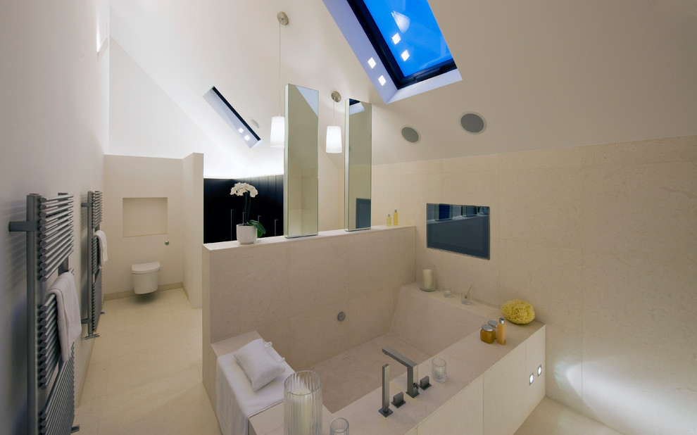 Inspiration for a large modern family bathroom in London with a japanese bath, a wall mounted toilet, beige tiles, beige walls and beige floors.