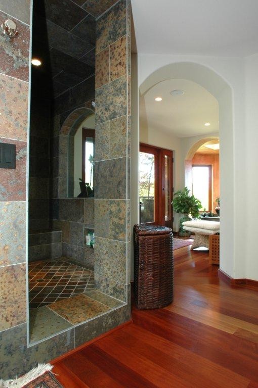 Стильный дизайн: большая главная ванная комната в восточном стиле с гидромассажной ванной, открытым душем, серой плиткой, каменной плиткой, розовыми стенами, темным паркетным полом, унитазом-моноблоком, коричневым полом и открытым душем - последний тренд