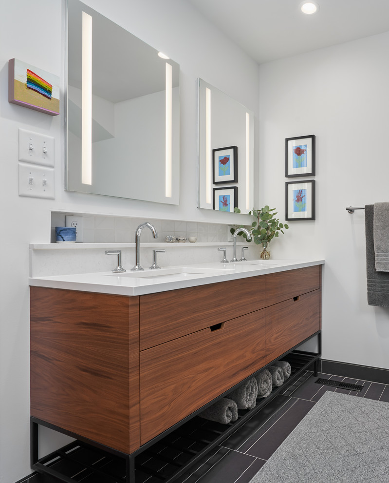 Свежая идея для дизайна: ванная комната в современном стиле с плоскими фасадами, фасадами цвета дерева среднего тона, белыми стенами, врезной раковиной, черным полом, белой столешницей и тумбой под две раковины - отличное фото интерьера