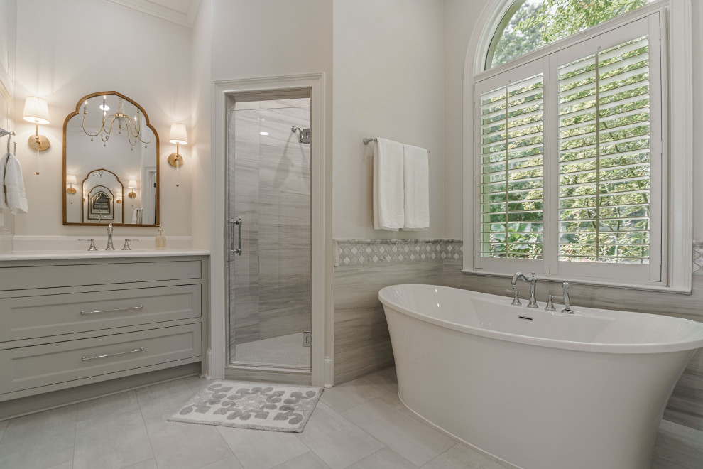 Idéer för ett stort klassiskt vit en-suite badrum, med luckor med profilerade fronter, grå skåp, ett fristående badkar, en hörndusch, grå kakel, porslinskakel, vita väggar, klinkergolv i porslin, ett undermonterad handfat, bänkskiva i kvartsit, grått golv och dusch med gångjärnsdörr