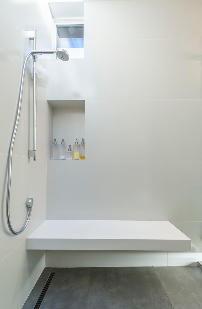Photo of a medium sized contemporary ensuite bathroom in Los Angeles with flat-panel cabinets, white cabinets, a freestanding bath, an alcove shower, a one-piece toilet, brown tiles, porcelain tiles, white walls, ceramic flooring, a submerged sink, solid surface worktops, beige floors and a hinged door.