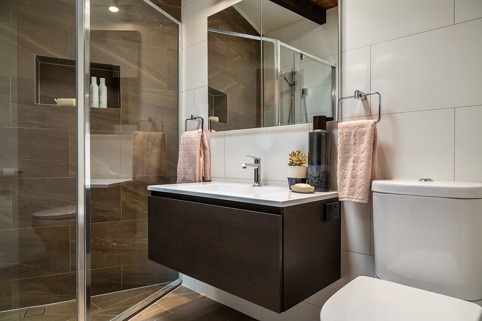 Стильный дизайн: маленькая главная ванная комната в стиле ретро с плоскими фасадами, темными деревянными фасадами, угловым душем, раздельным унитазом, коричневой плиткой, керамогранитной плиткой, белыми стенами, полом из керамогранита, монолитной раковиной, коричневым полом, душем с распашными дверями и белой столешницей для на участке и в саду - последний тренд