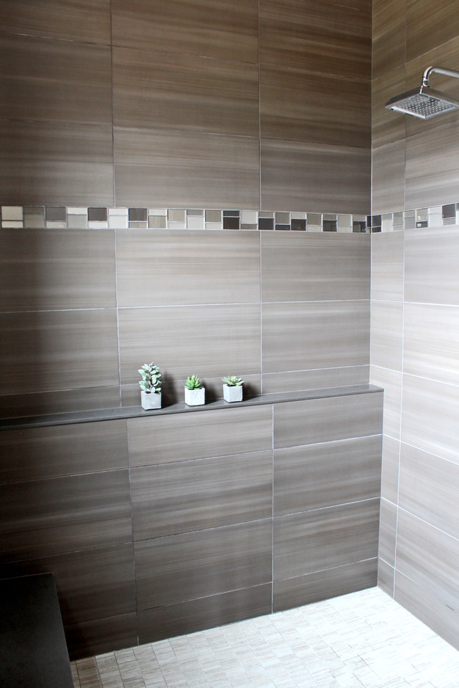 Foto på ett amerikanskt badrum, med ett fristående badkar, en öppen dusch och grå kakel