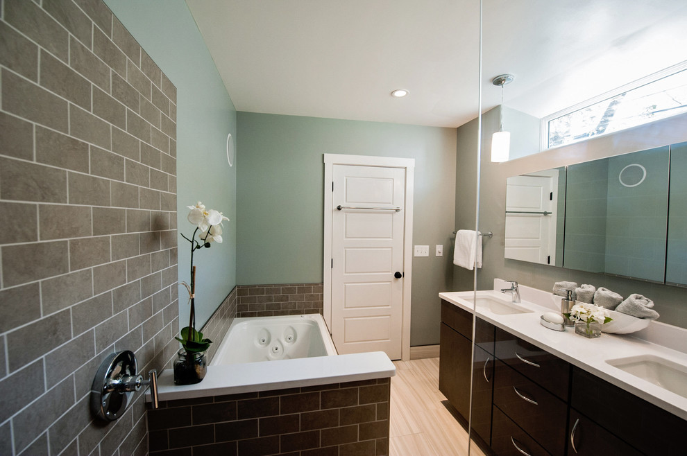 Design ideas for a small modern ensuite bathroom in Portland Maine with a submerged sink, flat-panel cabinets, dark wood cabinets, engineered stone worktops, a built-in bath, a built-in shower, a two-piece toilet, multi-coloured tiles, metro tiles, green walls and porcelain flooring.
