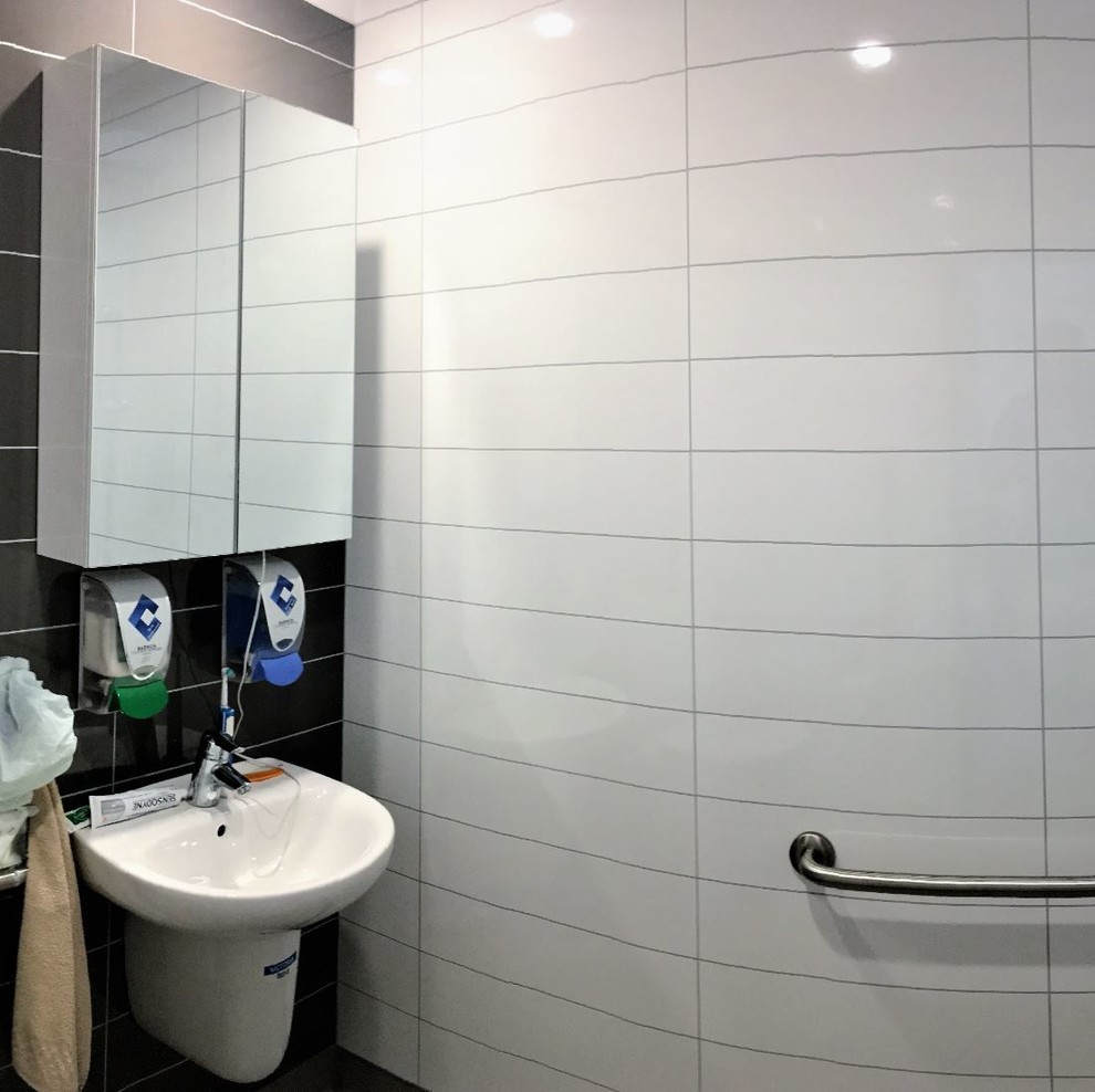 Cette photo montre une petite salle de bain principale tendance avec un espace douche bain, un carrelage gris, un sol en vinyl, un sol gris et aucune cabine.