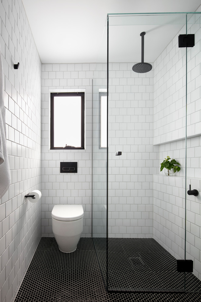 メルボルンにある小さな北欧スタイルのおしゃれなバスルーム (浴槽なし) (淡色木目調キャビネット、オープンシェルフ、バリアフリー、白いタイル、サブウェイタイル、白い壁、モザイクタイル、壁付け型シンク、人工大理石カウンター、開き戸のシャワー) の写真