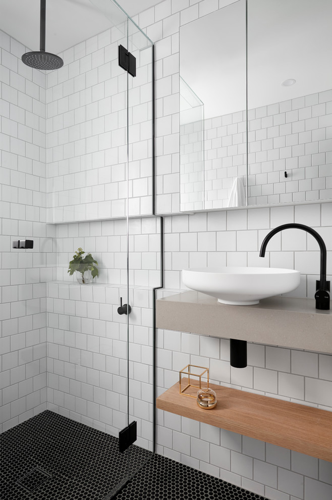 Small scandinavian bathroom in Melbourne with open cabinets, light wood cabinets, a built-in shower, white tiles, metro tiles, white walls, mosaic tile flooring, a wall-mounted sink, solid surface worktops and a hinged door.