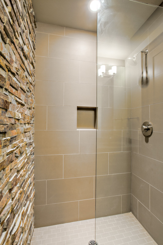 This is an example of a medium sized traditional shower room bathroom in Seattle with flat-panel cabinets, dark wood cabinets, a two-piece toilet, beige tiles, brown tiles, white tiles, stone tiles, grey walls, limestone flooring, a submerged sink and limestone worktops.