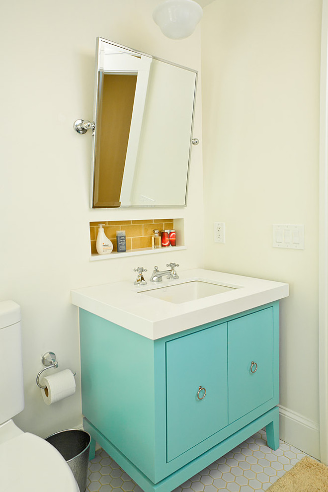 Immagine di una stanza da bagno costiera con lavabo sottopiano, ante lisce, ante blu, piastrelle gialle e piastrelle diamantate