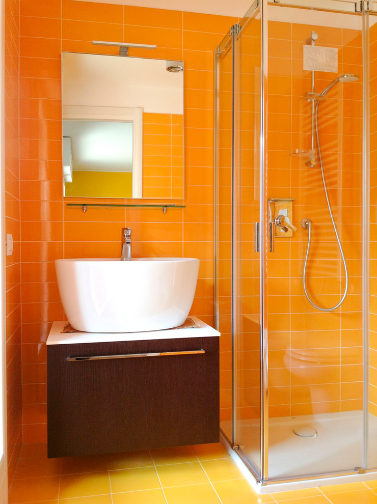 Example of a small minimalist kids' yellow tile and porcelain tile porcelain tile corner shower design in Milan with a console sink, flat-panel cabinets, brown cabinets, laminate countertops, a two-piece toilet and yellow walls