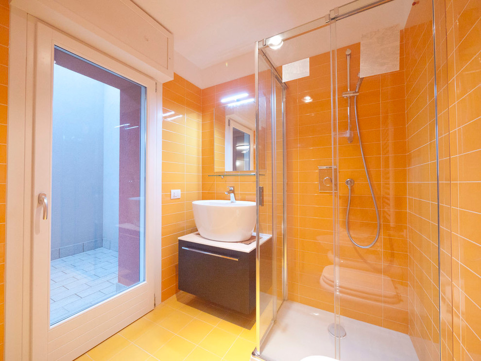 Exempel på ett litet modernt badrum för barn, med ett konsol handfat, släta luckor, bruna skåp, laminatbänkskiva, en hörndusch, en toalettstol med separat cisternkåpa, porslinskakel, gula väggar, klinkergolv i porslin och orange kakel