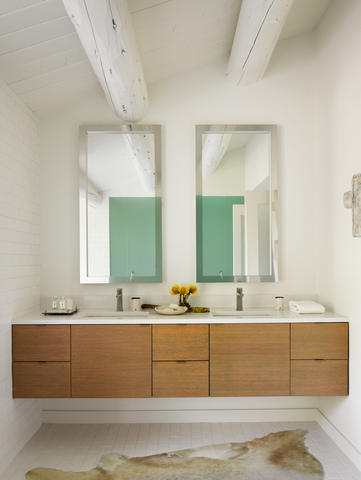 Aménagement d'une salle de bain contemporaine en bois brun avec un lavabo encastré, un placard à porte plane et un mur blanc.