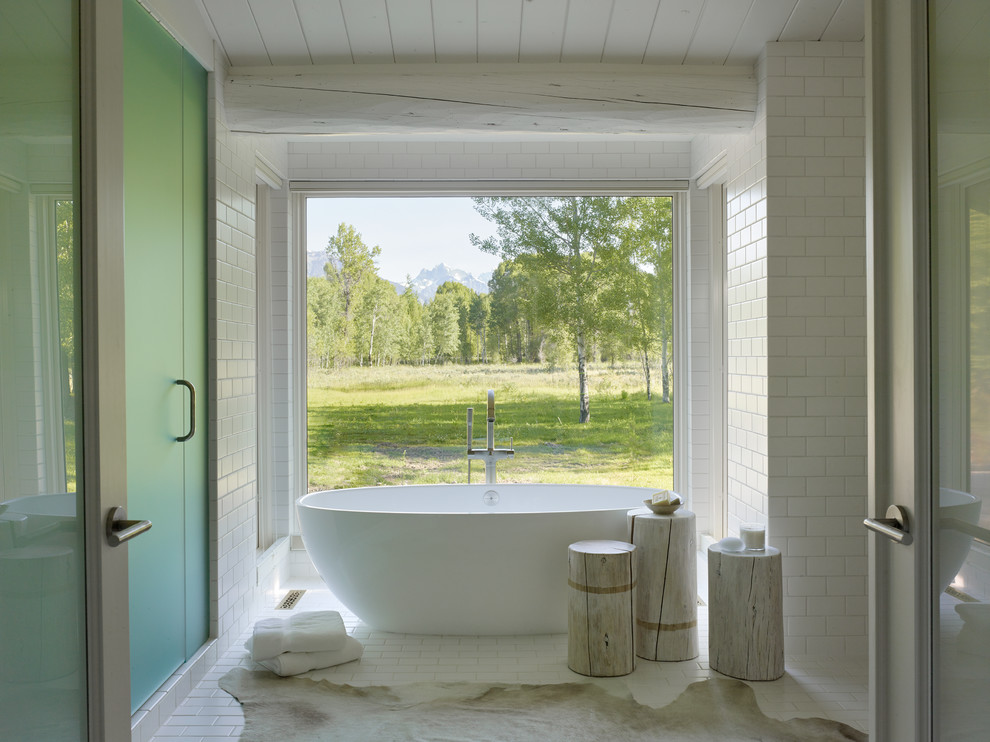 Ejemplo de cuarto de baño rural con bañera exenta, baldosas y/o azulejos blancos y baldosas y/o azulejos de cemento