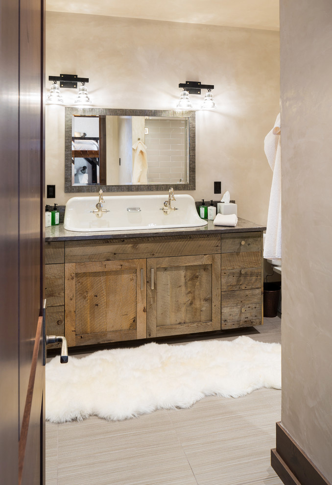 Cette image montre une salle de bain principale chalet avec un placard à porte shaker, un mur beige et une grande vasque.