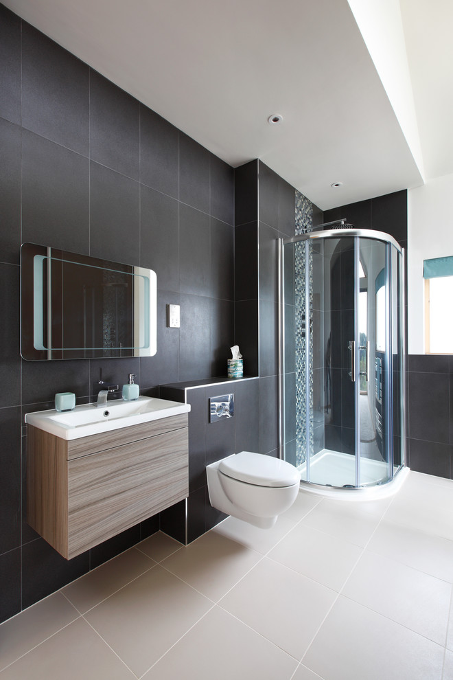 Photo of a large contemporary ensuite bathroom in Sussex with flat-panel cabinets, medium wood cabinets, a corner shower, black and white tiles, ceramic tiles, a built-in sink, a wall mounted toilet, black walls and ceramic flooring.