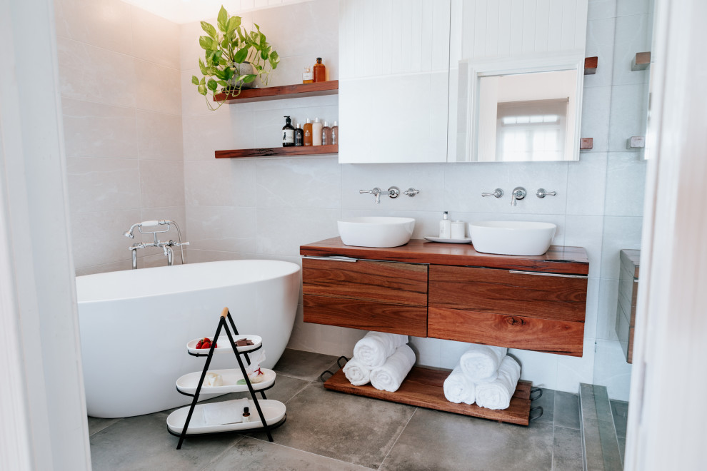 Industrial Badezimmer En Suite mit hellbraunen Holzschränken, freistehender Badewanne, grauen Fliesen, Keramikfliesen, Zementfliesen für Boden und Waschtisch aus Holz in Brisbane