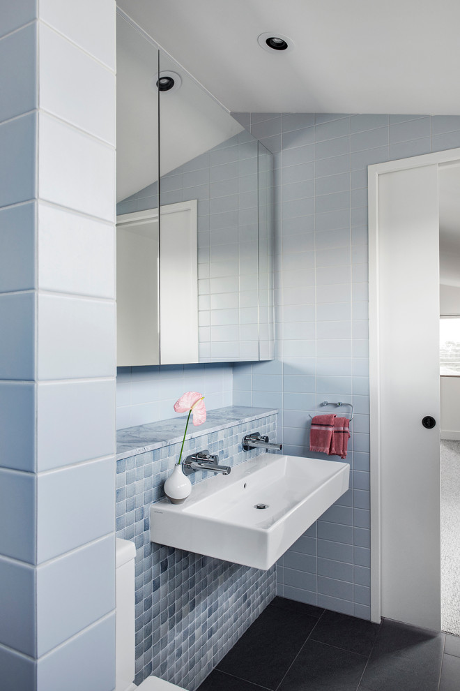 Idée de décoration pour une grande salle de bain design avec des portes de placard blanches, une baignoire en alcôve, WC à poser, un carrelage bleu, des carreaux de céramique, un mur blanc, un lavabo suspendu et une cabine de douche à porte battante.