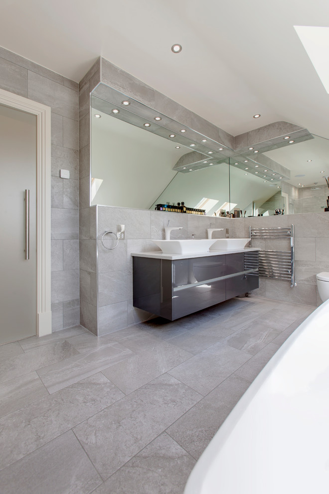 Exempel på ett modernt en-suite badrum, med släta luckor, vita skåp, ett fristående badkar, en öppen dusch, en vägghängd toalettstol, beige kakel, porslinskakel, klinkergolv i porslin, ett nedsänkt handfat och kaklad bänkskiva